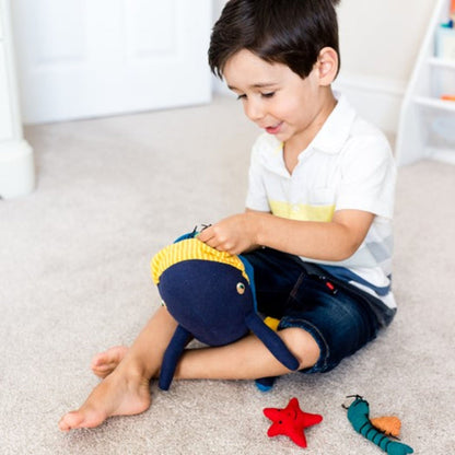 Child playing with the Fair Trade cotton whale and friends soft toy from Weaving Hope